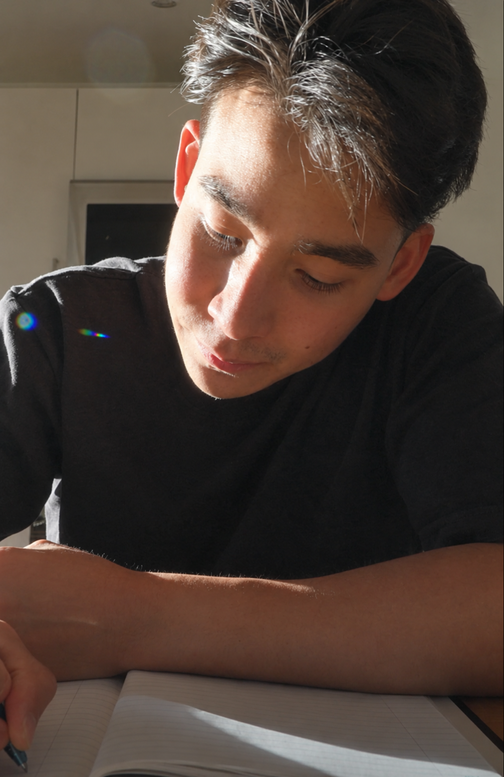 The founder writing notes at his desk in the sunlight